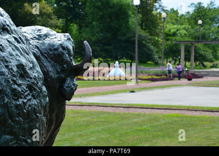 Bison monument looking off towards a quinceanera photo shoot in the Humboldt Park formal gardens on Chicago's west side. Stock Photo