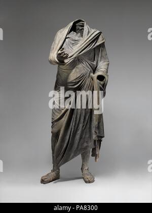 Bronze statue of a man. Culture: Greek. Dimensions: H. 73 in. (185.4 cm). Date: ca. mid-2nd-1st century B.C..  The figure stands in contrapposto. His right hand stretches out from the folds of his himation, with open palm and fingers curled upward in a gesture of oration. His left arm lays close to his body. The himation is kept in place in part by a tasselled weight, thrown over his left shoulder, which hangs at his calf. A rare detail, several horizontal bands decorate the fabric, and may have been painted or gilded. The indication of his musculature and anatomy continues underneath his garm Stock Photo