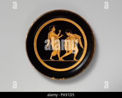 Terracotta plate. Culture: Greek, Attic. Dimensions: Diam.: 7 1/2 in. (19.1 cm). Date: ca. 510 B.C..  In the tondo, two revelers, one playing the double flute, the other holding a skyphos (deep drinking cup). Museum: Metropolitan Museum of Art, New York, USA. Stock Photo