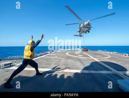 180720-N-HE318-1159 PHILIPPINE SEA (July 20, 2018) Boatswain’s Mate 3rd Class Aaron Mason, from Lafayette, Indiana, signals to a MH-60R Sea Hawk helicopter, assigned to the “Warlords” of Helicopter Maritime Strike Squadron (HSM) 51, as it hovers above the flight deck of the Ticonderoga-class guided-missile cruiser USS Antietam (CG 54). Antietam is forward-deployed in the U.S. 7th Fleet area of operations in support of security and stability in the Indo-Pacific region. (U.S. Navy photo by Mass Communication Specialist 2nd Class William McCann/Released) Stock Photo