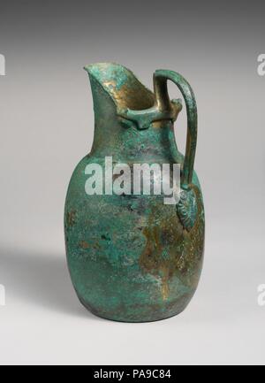 Bronze oinochoe (jug). Culture: Etruscan. Dimensions: H. 9 3/4 in. (24.8 cm). Date: ca. 550 B.C..  Beaked trefoil mouth. The handle attachment terminates in stylized animal heads with an elegant palmette at the base. Museum: Metropolitan Museum of Art, New York, USA. Stock Photo