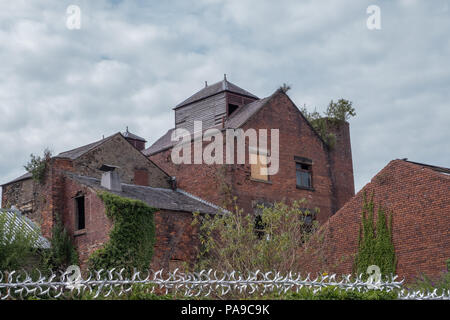 Derelict buildings in the centre of Lancaster city,UK with roof timbers and grass growing on the broken ruins Stock Photo