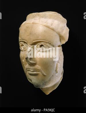 Head of a man. Dimensions: 9 1/2 in. (24 cm). Date: ca. 3rd-4th century A.D..  This fine male portrait head is thought to date from the middle of the first millennium A.D. and may have been part of a larger royal sculpture. The figure is wearing a stylized laurel wreath, a symbol of high rank. The use of the wreath to denote status reflects the influence of the Graeco-Roman world and appears in more realistic form on the coins of the kingdom of Himyar from the first centuries B.C. and A.D. A long mustache drapes along each side of the mouth, the chin is bearded, and a single ringlet is careful Stock Photo