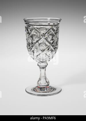 Goblet. Culture: American. Dimensions: H. 6 11/16 in. (17 cm); Diam. 3 1/2 in. (8.9 cm). Date: 1850-60.  With the development of new formulas and techniques, glass-pressing technology had improved markedly by the late 1840s. By this time, pressed tablewares were being produced in large matching sets and innumerable forms. During the mid-1850s, colorless glass and simple geometric patterns dominated. Catering to the demand for moderately-priced dining wares, the glass industry in the United States expanded widely, and numerous factories supplied less expensive pressed glassware to the growing m Stock Photo