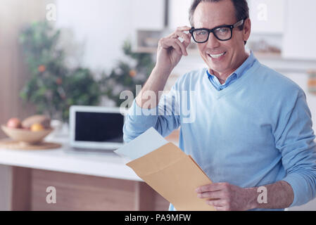 Joyful nice man holding an envelope Stock Photo