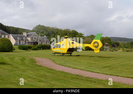 An air ambulance helicopter landed on the lawns outside the Lawson Memorial Hospital in Golspie, Scottish Highlands Stock Photo