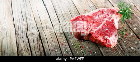 Raw T-Bone Steak On Wooden With Rosemary And Pink Pepper Stock Photo
