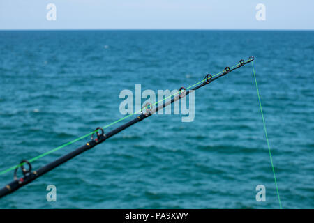 Fishing Rod Against Blue Ocean or Sea Background, Copy Space