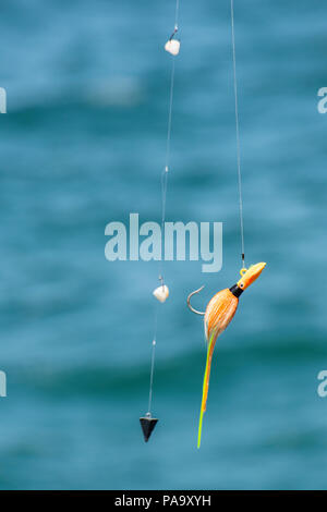 A fishing lure against the blue ocean. Stock Photo