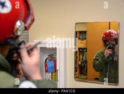 Brendan Lyons, Tucson community hometown hero, uses a mirror to practice securing an oxygen mask to a helmet prior to his flight in an F-16 Fighting Falcon, from the U.S. Air Force Air Demonstration Squadron, at Davis-Monthan Air Force Base, Ariz., March 11, 2016.  Lyons was nominated as a hometown hero to fly with the Thunderbirds because of his commitment to safety and his passion to make Tucson a safer community for cyclists and motorists. (U.S. Air Force photo by Senior Airman Chris Massey/Released) Stock Photo