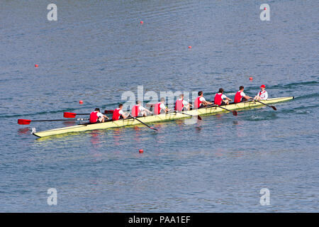 Rowers in eight-oar rowing boats on the tranquil lake Stock Photo