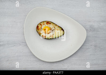 One egg baked in avocado on plate Stock Photo