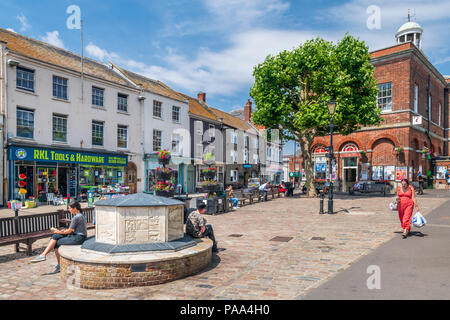 On a warm afternoon in July, shoppers enjoy the sunshine in the square at Bridport outside the Tourist Information Centre. Stock Photo