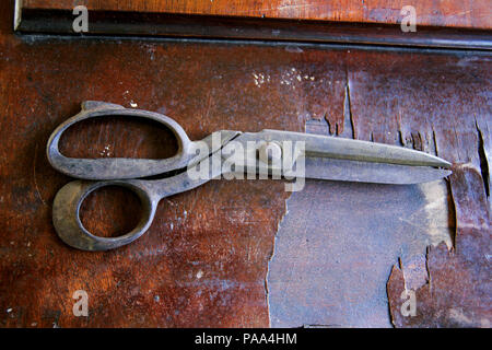 Old metal tailors scissors on the wooden table Stock Photo