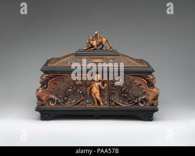 Jewelry casket. Culture: Italian, Siena. Dimensions: 11 x 15 x 10-1/4 in.  (27.9 x 38.1 x 26.0 cm). Maker: Pietro Giusti (Italian, 1822-1878). Date: 1857.  Pietro Giusti, one of the most successful nineteenth-century designers and sculptors in Tuscany, was known for his elaborately carved frames and furniture in sixteenth-century styles. Here, Giusti may have been inspired by the work of the Renaissance artist Antonio Barili (1453-1516); Guisti was probably familiar with Barili's cassone surmounted by the she-wolf with Romulus and Remus and with fabled monsters at the four corners in the Museo Stock Photo