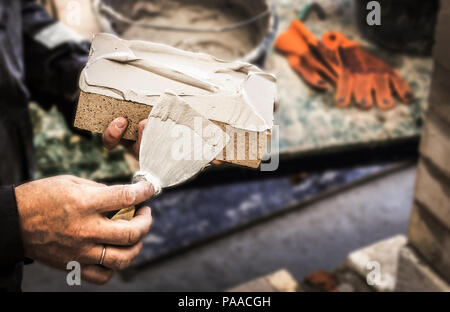 hands with a brick and building trowel Stock Photo