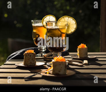 Pancakes with caviar and tea with lemon stand on the table Stock Photo