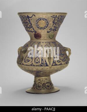 Mosque Lamp of Sultan Barquq. Dimensions: H. 14 5/8 in. (37.1 cm)  Max. diam. 9 5/8 in. (24.4 cm)  Diam. with handles: 10 1/16 in. (25.6 cm). Date: ca. 1382-99.  As the ambitious design on this lamp demonstrates, by the late fourteenth century, glassmakers had resolved the difficulty of applying enamel to the underside of their vessels and continued their pursuit of ever-larger sizes. Dedicated to Sultan Barquq (r. 1382-89, 1390-99), this piece bears the epigraphic type of blazon adopted by sultans at this time. Museum: Metropolitan Museum of Art, New York, USA. Stock Photo