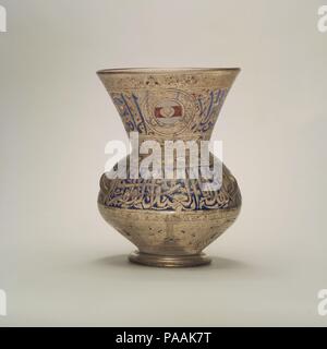 Mosque Lamp of Amir Ahmad al-Mihmandar. Dimensions: H. 10 1/2in. (26.7cm)  Max. diam. 8 3/16 in. (20.8 cm). Date: ca. 1325.  According to its inscription, Ahmad al-Mihmandar (d. 1332) donated this lamp--probably one of several-- to the madrasa that he erected in Cairo in 1324-25. His blazon, a white disk charged with a gold shield against a red bar, appears six times, amid a Qur'anic inscription on the neck (Sura 9:18) and against dense foliage on the underside. Museum: Metropolitan Museum of Art, New York, USA. Stock Photo