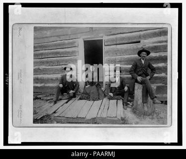 A partial view of the Lincoln cabin with open door and group of four including Mr. Thomas Lincoln's grandson John J. Hall - Root, Kimball Hall Studio, 243 Wabash Ave., Chicago. Stock Photo