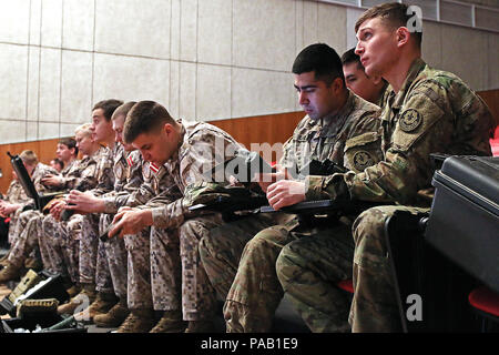 Pfc. Justin Giaimo (right), and Spc. Fortino Licea (second on right), both indirect fire infantrymen assigned to Headquarters and Headquarters Troop, 3rd Squadron, 2nd Cavalry Regiment learn to operate the lightweight handheld mortar ballistic computer during an Infantry Mortar Leaders Course alongside Latvian allies, March 3, at Adazi Military Base, Latvia. Latvian and American soldiers received classroom instruction and hands-on training during the five-day course in support of Operation Atlantic Resolve, a multinational demonstration of continued U.S. commitment to the collective security o Stock Photo