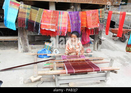 women engaged in traditional weaving at the indonesian island of sumatra. Stock Photo