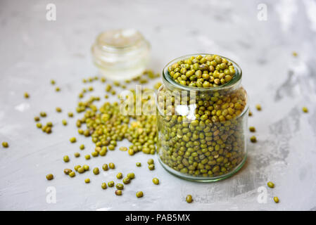 Mung beans in glass jar on grey concrete background. Text space Stock Photo
