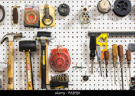 Assorted tools hanging on pegboard Stock Photo