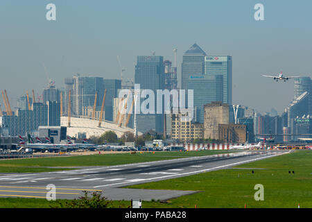 An Airbus A220-100 on final approach into London City Airport, with the towers of the Canary Wharf financial district and The O2 in the background Stock Photo