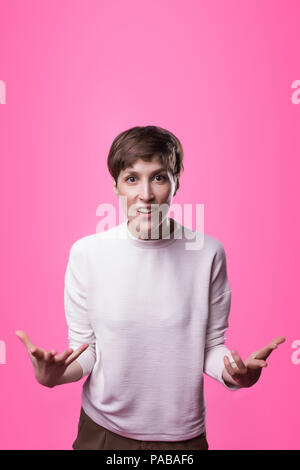 Argue, arguing concept. Beautiful female half-length portrait isolated on pink studio backgroud. Stock Photo