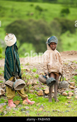 AKSUM, ETHIOPIA - SEPTEMBER 22, 2011: Unidentified Ethiopian children sell souvenirs with the green nature background. People in Ethiopia suffer of po Stock Photo