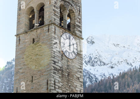 View of the church bell tower between the forest in autumn, in the Gressoney Valley situated in the Aosta Valley, northern Italy. Stock Photo