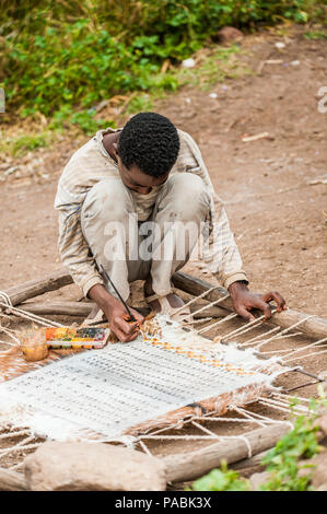 OMO, ETHIOPIA - SEPTEMBER 21, 2011: Unidentified Ethiopian boy is painting. People in Ethiopia suffer of poverty due to the unstable situation Stock Photo