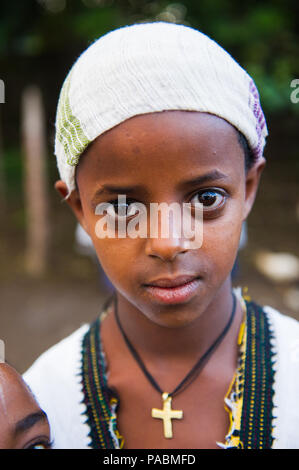 AKSUM, ETHIOPIA - SEP 27, 2011: Portrait of an unidentified Ethiopian little girl with a golden cross in Ethiopia, Sep.27, 2011. Children in Ethiopia  Stock Photo