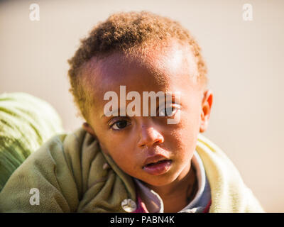 LALIBELA, ETHIOPIA - SEPTEMBER 28, 2011: Unidentified Ethiopian girl watches the camera. People in Ethiopia suffer of poverty due to the unstable situ Stock Photo