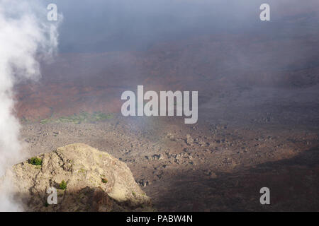 A partial rainbow reflecting of hazy clouds over a red, barren landscape at the Leleiwi Overlook in Haleakala National Park, Kula, Maui, Hawaii, USA Stock Photo