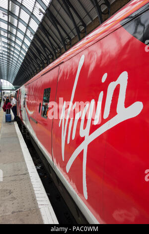 A Virgin Train logo on the side of a locomotive at Kings Cross Railway Station, London, UK Stock Photo