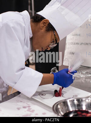 Pfc. Tyquanda Dennis, with the 275th Quartermaster Company, Fort Pickett, Va., puts the finishing touches on her entry during the Armed Forces Junior Chef of the Year competition during the 41st Annual Military Culinary Arts Competitive Training Event at the Joint Culinary Center of Excellence, March 6, 2016, at Fort Lee, Va. Dennis, who has been on the U.S. Army Reserve Culinary Arts Team for only three days, scored a bronze medal in her first competition. (U.S. Army photo by Timothy L. Hale/Released) Stock Photo