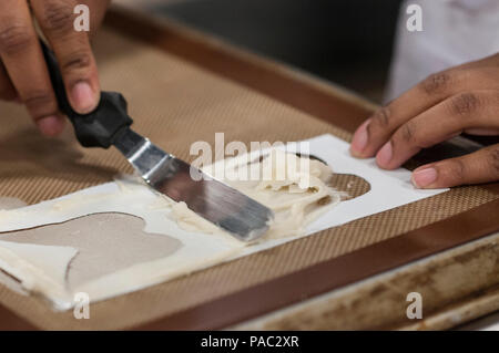 Pfc. Tyquanda Dennis, with the 275th Quartermaster Company, Fort Pickett, Va., applies tuile (baked wafer) to a baking sheet for her entry during the Student Chef of the Year competition during the 41st Annual Military Culinary Arts Competitive Training Event at the Joint Culinary Center of Excellence, March 6, 2016, at Fort Lee, Va. Dennis, who has been on the U.S. Army Reserve Culinary Arts Team for only three days, scored a bronze medal in her first competition. (U.S. Army photo by Timothy L. Hale/Released) Stock Photo