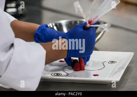 Pfc. Tyquanda Dennis, with the 275th Quartermaster Company, Fort Pickett, Va., puts the finishing touches on her entry during the Armed Forces Junior Chef of the Year competition during the 41st Annual Military Culinary Arts Competitive Training Event at the Joint Culinary Center of Excellence, March 6, 2016, at Fort Lee, Va. Dennis, who has been on the U.S. Army Reserve Culinary Arts Team for only three days, scored a bronze medal in her first competition. (U.S. Army photo by Timothy L. Hale/Released) Stock Photo