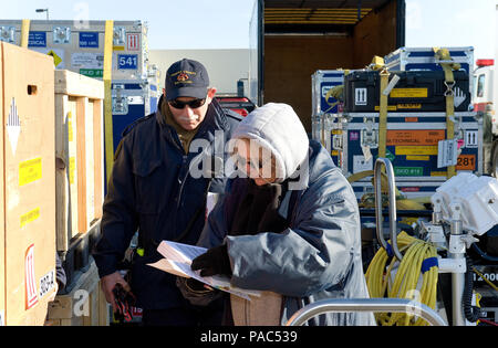 Bruce Newhaus, Fairfax County Fire and Rescue Department, Va.: Virginia Task Force 1 logistics manager, and Anna Reed, 436th Aerial Port Squadron hazardous material inspector processor, inspect cargo and review paperwork March 3, 2016, at the 436th APS marshalling yard on Dover Air Force Base, Del. Newhaus and Reed ensured all cargo being loaded onto a C-5M Super Galaxy was properly documented and noted as airworthy. (U.S. Air Force photo/Roland Balik) Stock Photo