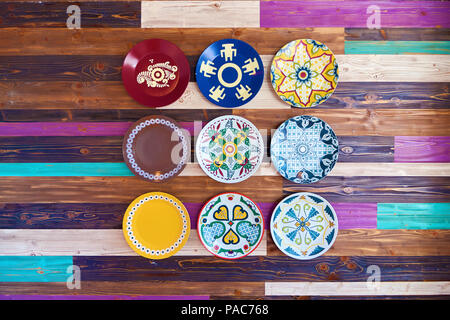 Grunge painted wooden wall with decorative colorful plates Stock Photo