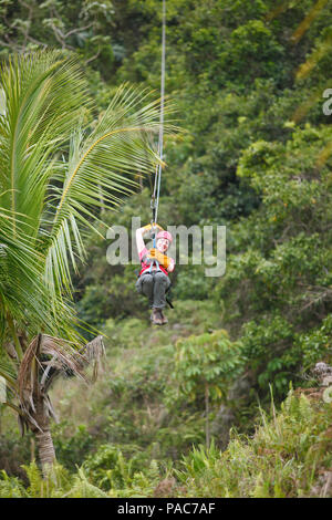 Woman, 38, riding a zipline through the jungle, Samaná province, Dominican Republic Stock Photo