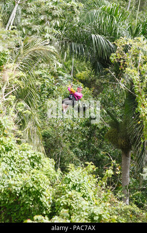 Woman, 40, riding a zipline through the jungle, Samaná province, Dominican Republic Stock Photo