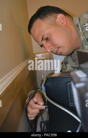 Staff Sgt. Hector Marrero an Information Technology Specialist assigned to the 80th Training Command, works on personal computer at The Army School System Training Center, Grand Prairie, Texas, March 7, 2016. Stock Photo