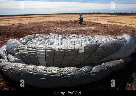 A paratrooper stows her parachute after jumping from New Jersey Army National Guard UH-60 Black Hawks with the 1-150th Assault Helicopter Battalion in a joint training airborne operation with paratroopers from the U.S. Army Reserves’ 353rd Civil Affairs Command, 304th Civil Affairs Brigade, 404th Civil Affairs Battalion (Airborne) and the 450th Civil Affairs Battalion, along with Joint Tactical Air Control Airmen from the New Jersey Air National Guard's 227th Air Support Operations Squadron and the New York Air National Guard's 274th Air Support Operations Squadron at Coyle Drop Zone, Joint Ba Stock Photo