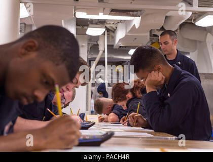 160317-N-GW139-009  WATERS NEAR GUAM (Mar. 17, 2016) - Sailors aboard Arleigh Burke-class guided missile destroyer USS Fitzgerald (DDG 62) take an advancement exam on the mess decks. Fitzgerald is on patrol in the 7th Fleet area of operations in support of security and stability in the Indo-Asia-Pacific. (U.S. Navy photo by Mass Communication Specialist 3rd Class Eric Coffer/Released) Stock Photo