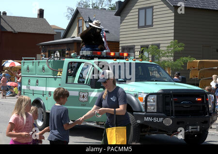 A US Forest Service truck in a July 4th parade with Smokey The Bear Stock Photo