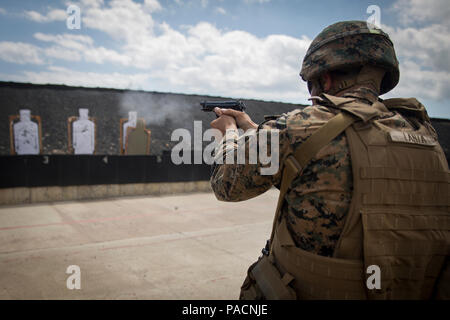 Cpl. Mario Lanza fires his M9 Beretta pistol at the final target in a course of fire on the Kaneohe Bay Range Training Facility aboard Marine Corps Base Hawaii, March 15, 2016. Lanza is a small-arms repairer with 1st Battalion, 12th Marine Regiment. The Marine Corps Combat Shooting Team facilitated the first ever Pacific Combat Shooting Match from March 14-17. The Marines who participated completed several different courses of fire that tested their ability to switch weapons, reload ammunition and engage targets on the fly. (U.S. Marine Corps photo by Sgt. Matthew J. Bragg) Stock Photo