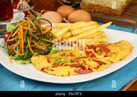 Breakfast omelette with french fries and garnish Stock Photo